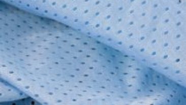 Blue mesh sport wear fabric textile pattern background. Blue color football jersey clothing fabric texture sports wear. Breathable porous poriferous material air ventilation with small holes